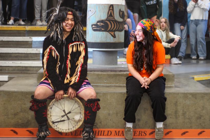 two students sitting on a ledge